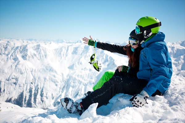 Young happy couple in snowy mountains.