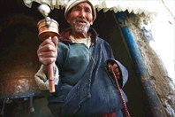 Старик с ручной молитвенной мельницей