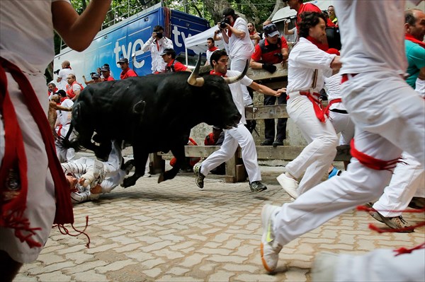 Участники Празднований бегут от быков