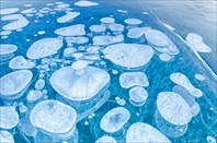Methane bubbles trapped in ice in an Alberta, Canada lake.-озеро Абрахам
